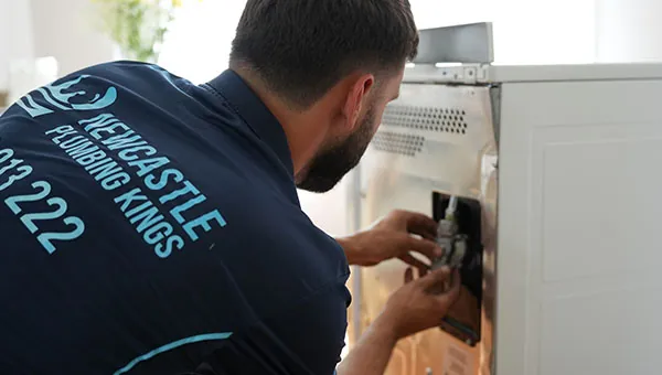 Plumber working on a gas oven connection